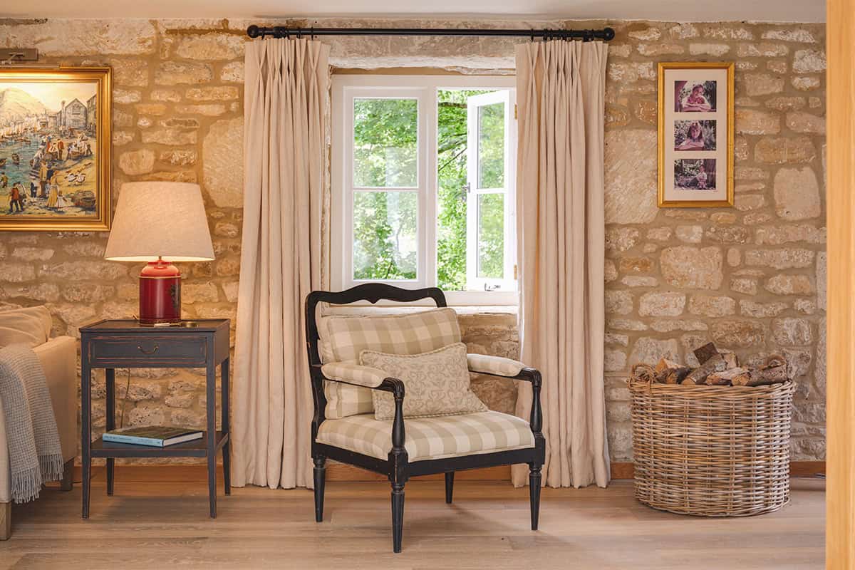 The Mount cosy sitting room with stone fireplace, woodburner and red velvet sofa, Cotswolds cottage